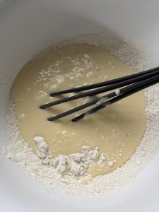 Dry muffin ingredients in bowl with wet ingredients added but not combined