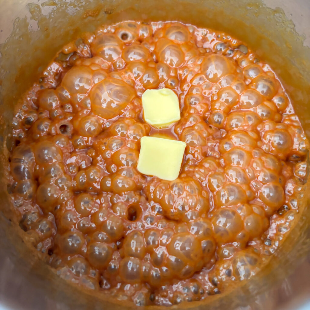 Caramel boiling in pan with butter cubes added