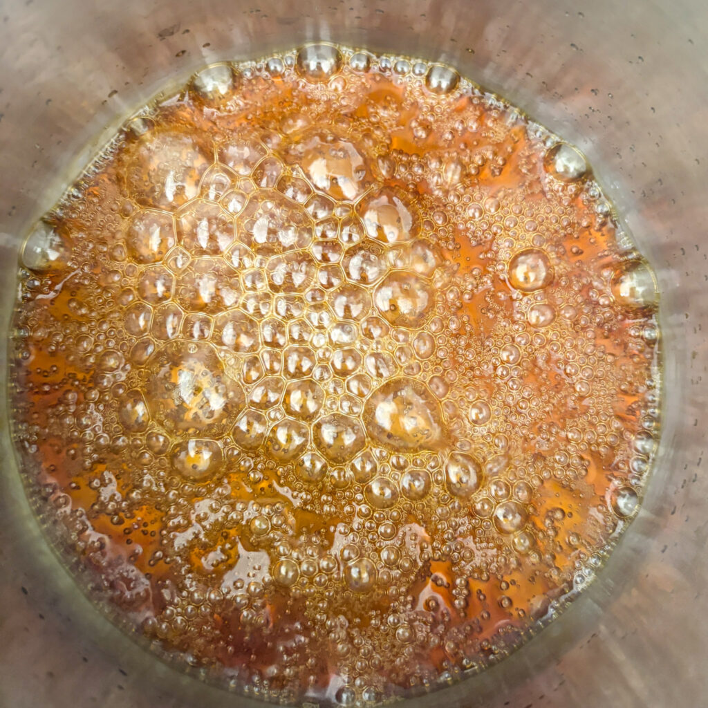 Sugar syrup boiling in pan rich amber colour