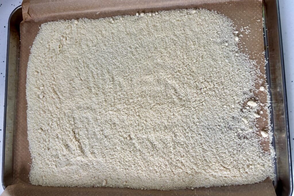 Almond Flour on baking tray being dried out to reduce oiliness