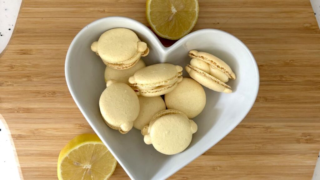 Finished lemon macarons displayed with fresh lemon slices