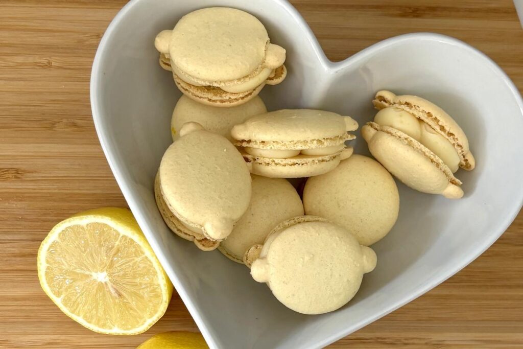 Finished lemon macarons displayed with fresh lemon slices