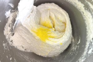 Lemon Macarons process step showing yellow food colouring powder being added to macaron batter