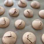 Cracked macarons on tray for cracked macaron troubleshooting tips blog post