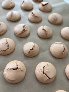 Cracked macarons on tray for cracked macaron troubleshooting tips blog post